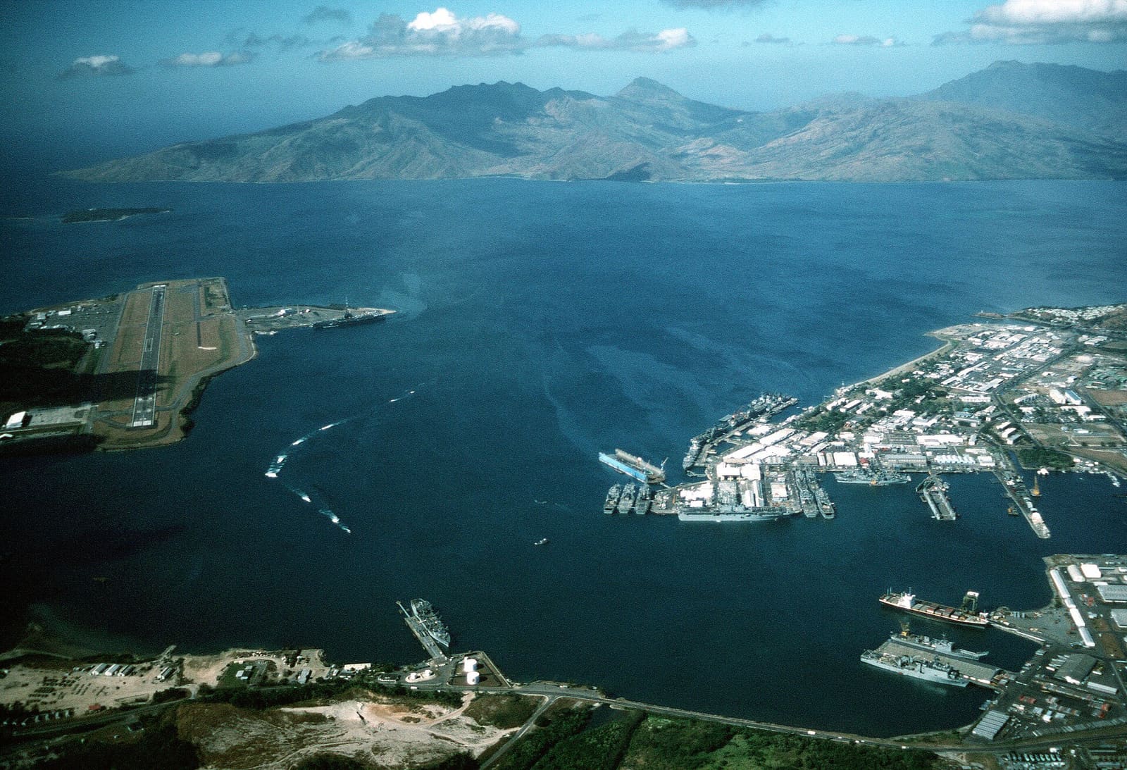 Aerial view of the U.S. Navy Naval Station Subic Bay, Philippines, circa in 1990, with Naval Air Station Cubi Point visible on the left.